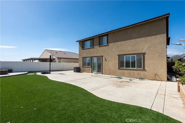 6594 June Mountain Way, Jurupa Valley, CA 92509 - rear view of house with a patio, central AC unit, fence, stucco siding, and a lawn