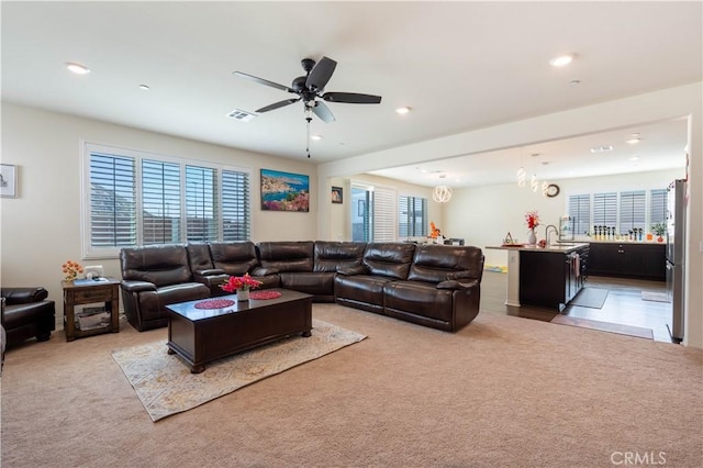 6594 June Mountain Way, Jurupa Valley, CA 92509 - living room with light colored carpet, a ceiling fan, and a healthy amount of sunlight