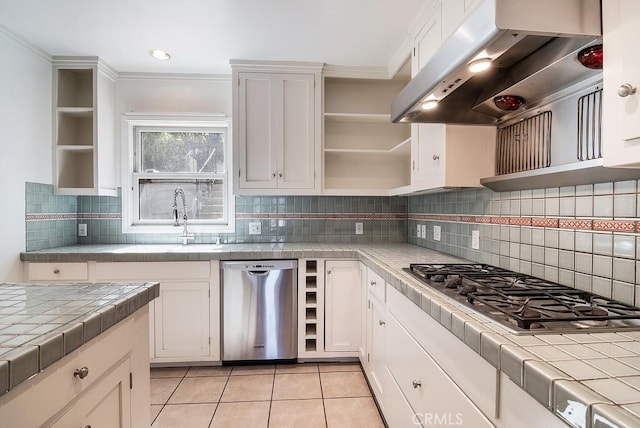 kitchen featuring light tile patterned floors, open shelves, tile counters, appliances with stainless steel finishes, and exhaust hood