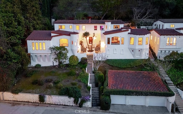 view of front of house with stairway, stucco siding, and a tile roof