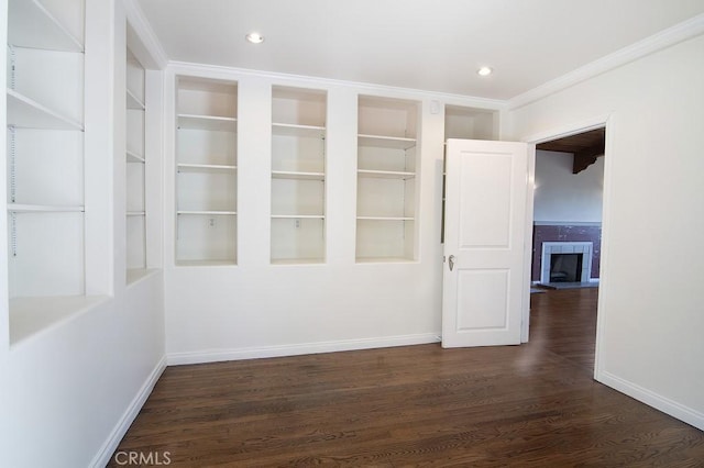 empty room featuring recessed lighting, baseboards, dark wood-style floors, and a tile fireplace