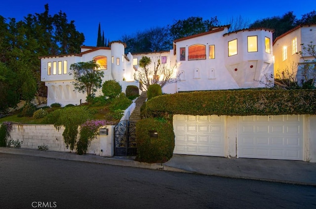 mediterranean / spanish house with a garage, driveway, and stucco siding