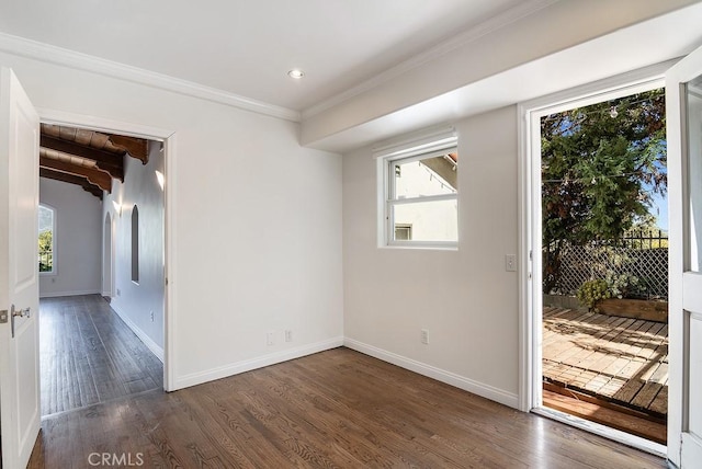 spare room with crown molding, wood finished floors, and baseboards