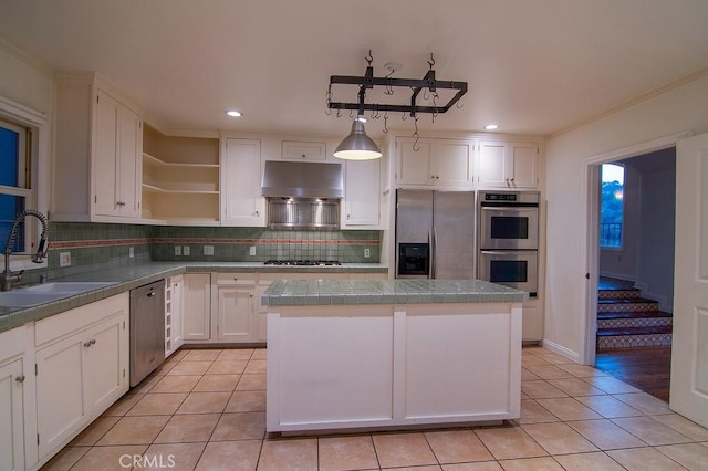 kitchen featuring a center island, under cabinet range hood, light tile patterned floors, appliances with stainless steel finishes, and a sink