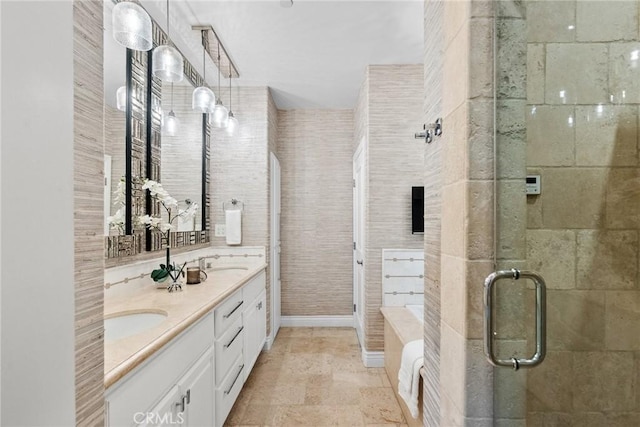 bathroom with a sink, double vanity, a shower stall, and stone finish floor