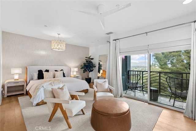 bedroom with access to exterior, visible vents, and light wood-style floors