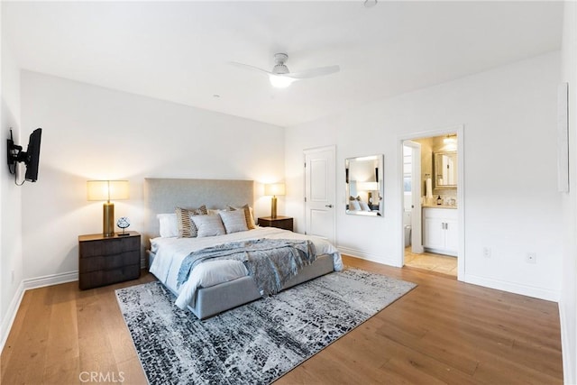 bedroom featuring light wood-style flooring, baseboards, and connected bathroom