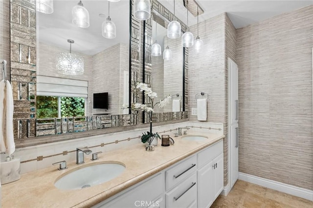 bathroom featuring double vanity, baseboards, and a sink