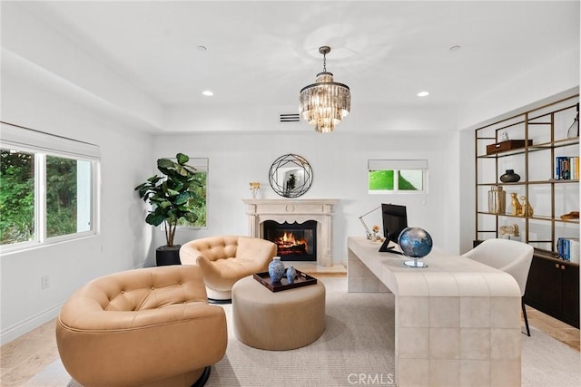 living room with visible vents, baseboards, a chandelier, a lit fireplace, and recessed lighting