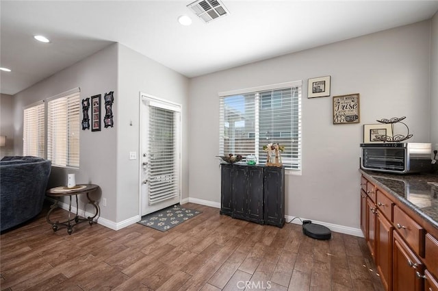 foyer entrance featuring a wealth of natural light, baseboards, and dark wood finished floors