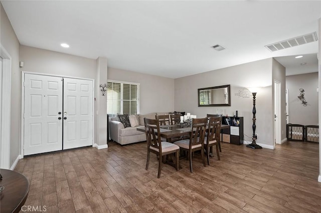 dining room featuring wood finished floors, visible vents, and baseboards