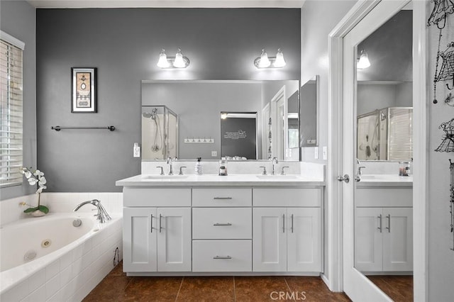 bathroom with tile patterned floors, a whirlpool tub, a stall shower, and a sink