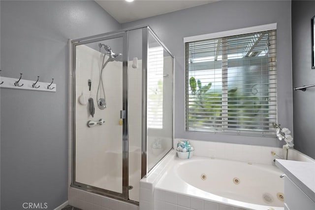 bathroom featuring plenty of natural light, a stall shower, and a whirlpool tub