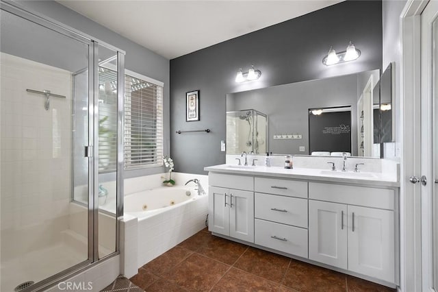 full bathroom featuring tile patterned flooring, a jetted tub, double vanity, a stall shower, and a sink