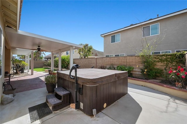 view of patio / terrace with ceiling fan, a fenced backyard, and a hot tub