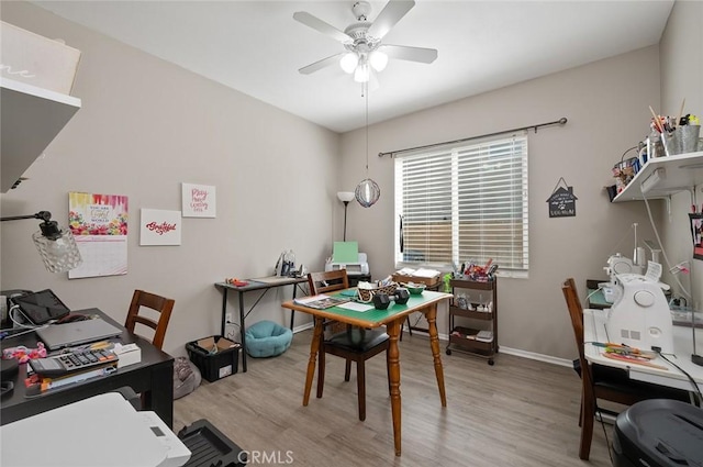 office space featuring light wood-type flooring, baseboards, and a ceiling fan