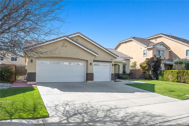 view of front of property featuring a gate, stucco siding, an attached garage, and a tiled roof