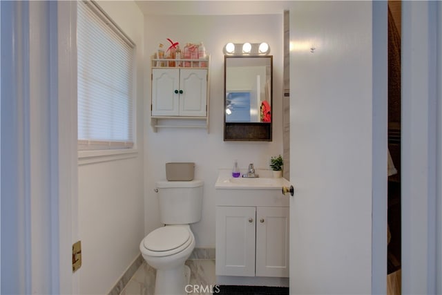 bathroom featuring vanity, toilet, baseboards, and marble finish floor