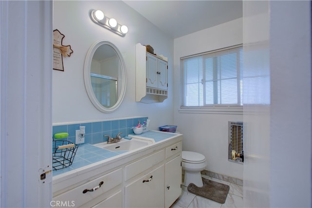 bathroom featuring tasteful backsplash, baseboards, toilet, marble finish floor, and vanity