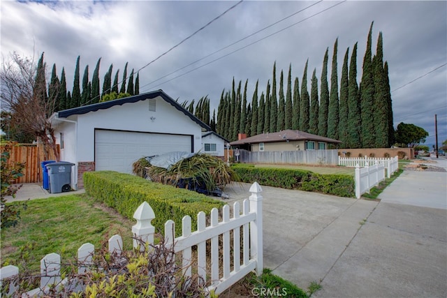 view of front of home featuring a fenced front yard, an outbuilding, and stucco siding