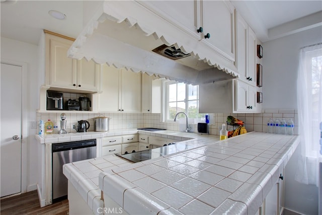 kitchen featuring tile countertops, decorative backsplash, stainless steel dishwasher, and a peninsula