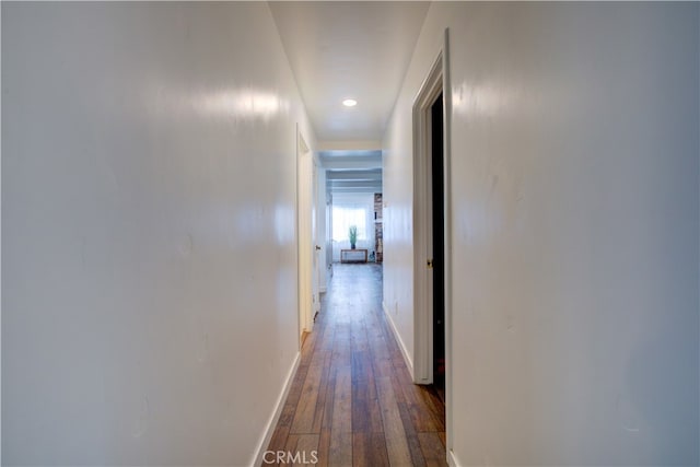 hall with baseboards and hardwood / wood-style flooring