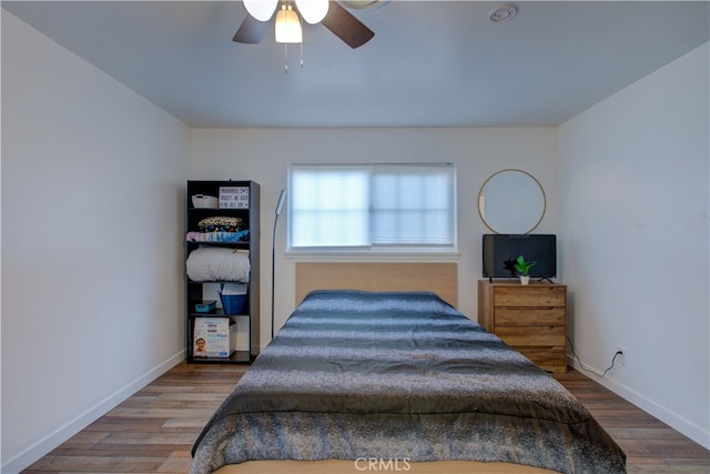 bedroom featuring a ceiling fan, wood finished floors, and baseboards