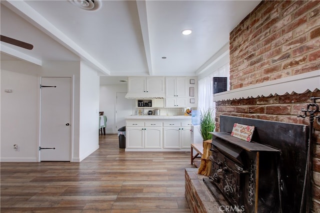 kitchen featuring beam ceiling, white cabinetry, light wood finished floors, baseboards, and light countertops