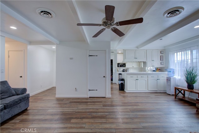 living room featuring beamed ceiling, wood finished floors, visible vents, and baseboards