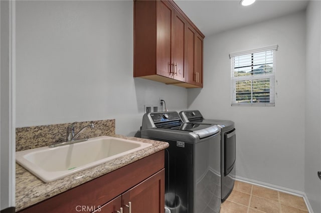 laundry area with independent washer and dryer, a sink, cabinet space, light tile patterned floors, and baseboards