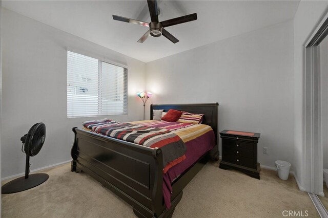 bedroom featuring a ceiling fan, light colored carpet, and baseboards