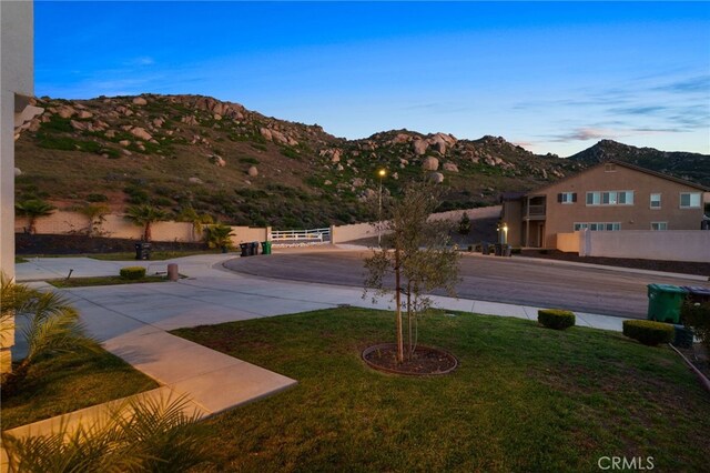 view of yard featuring fence and a mountain view