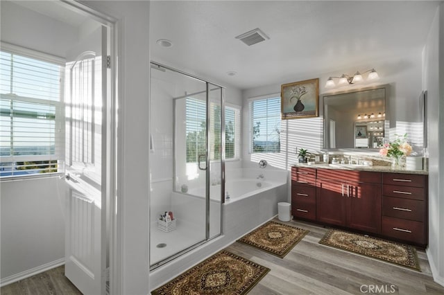 full bathroom with visible vents, wood finished floors, a shower stall, a bath, and vanity