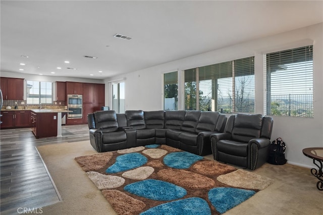 living area featuring visible vents, recessed lighting, and dark wood-style flooring