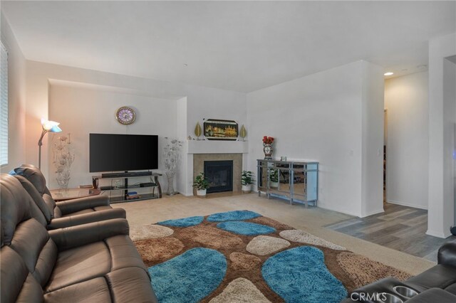 living area featuring a fireplace with flush hearth and carpet