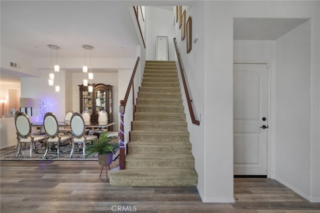 stairs featuring visible vents, baseboards, and wood finished floors