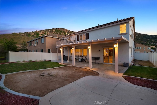 rear view of property featuring stucco siding, a patio, a lawn, and a fenced backyard