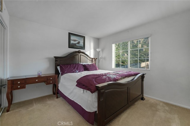 bedroom with light colored carpet and baseboards