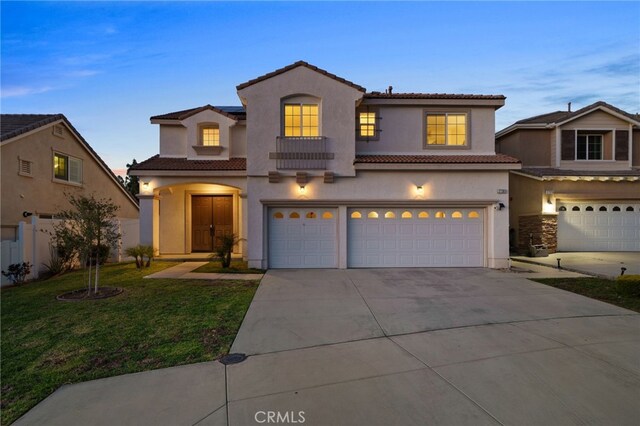 view of front of home featuring driveway, stucco siding, a garage, a tiled roof, and a lawn