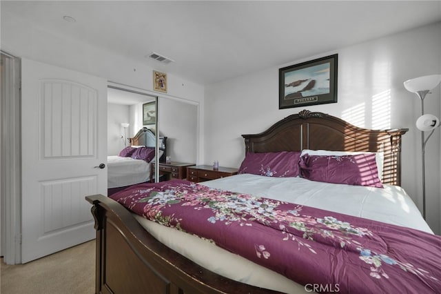 bedroom featuring visible vents, light carpet, and a closet