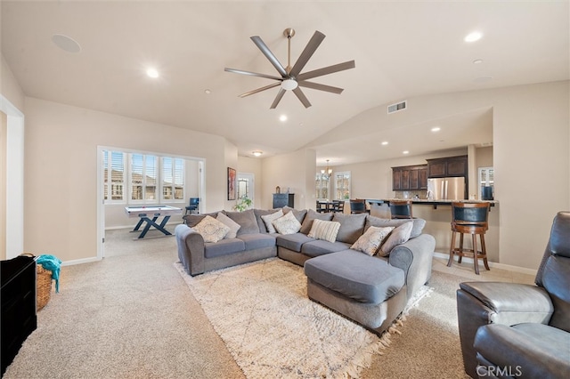 living room with visible vents, plenty of natural light, light carpet, and vaulted ceiling