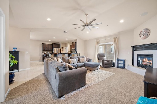 living room featuring visible vents, a glass covered fireplace, recessed lighting, light colored carpet, and vaulted ceiling