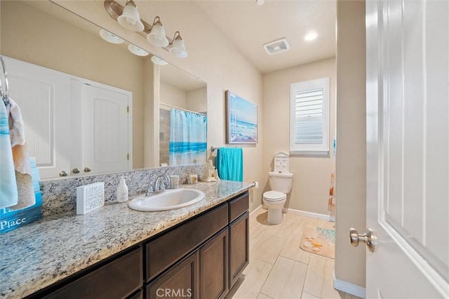 full bath featuring vanity, toilet, baseboards, and visible vents