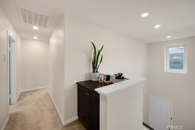 corridor featuring recessed lighting, visible vents, baseboards, and light colored carpet