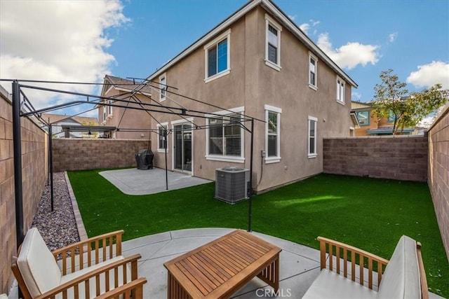 back of house featuring stucco siding, a lawn, a fenced backyard, cooling unit, and a patio area