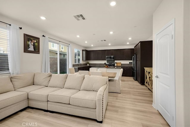 living area with recessed lighting, visible vents, and light wood-style flooring