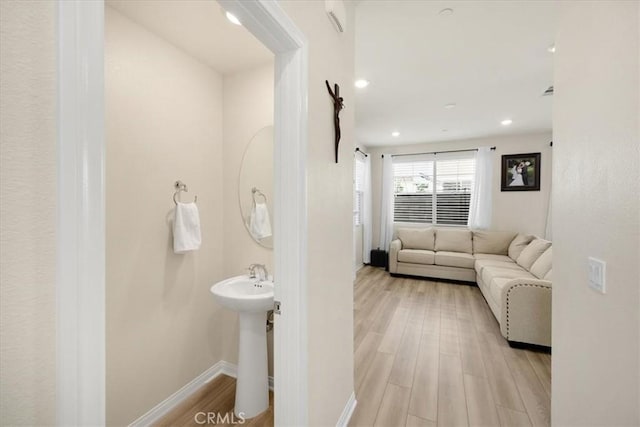 bathroom featuring a sink, recessed lighting, baseboards, and wood finished floors