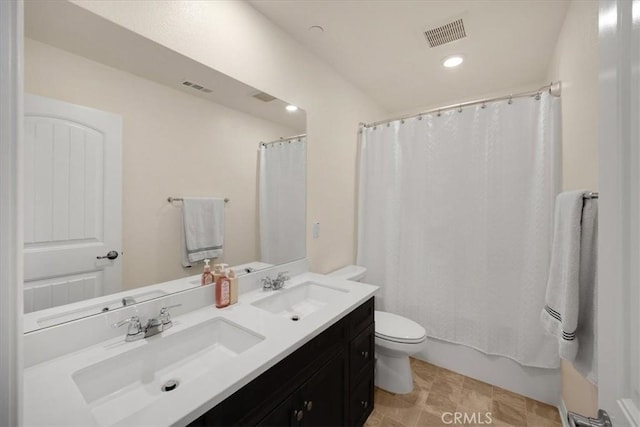 bathroom with toilet, visible vents, and a sink