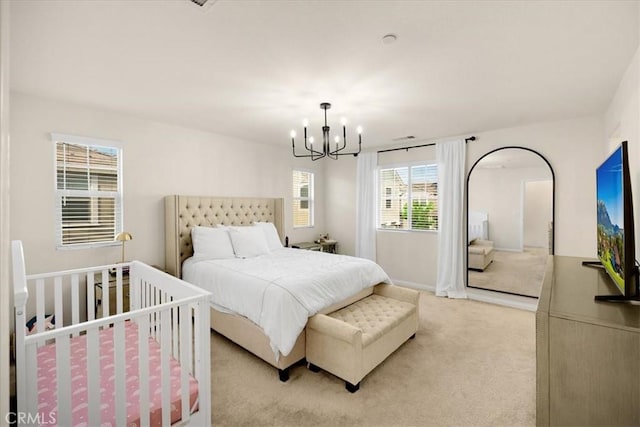 bedroom with light carpet and an inviting chandelier