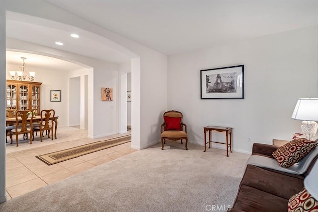 sitting room with light tile patterned floors, recessed lighting, arched walkways, and light carpet